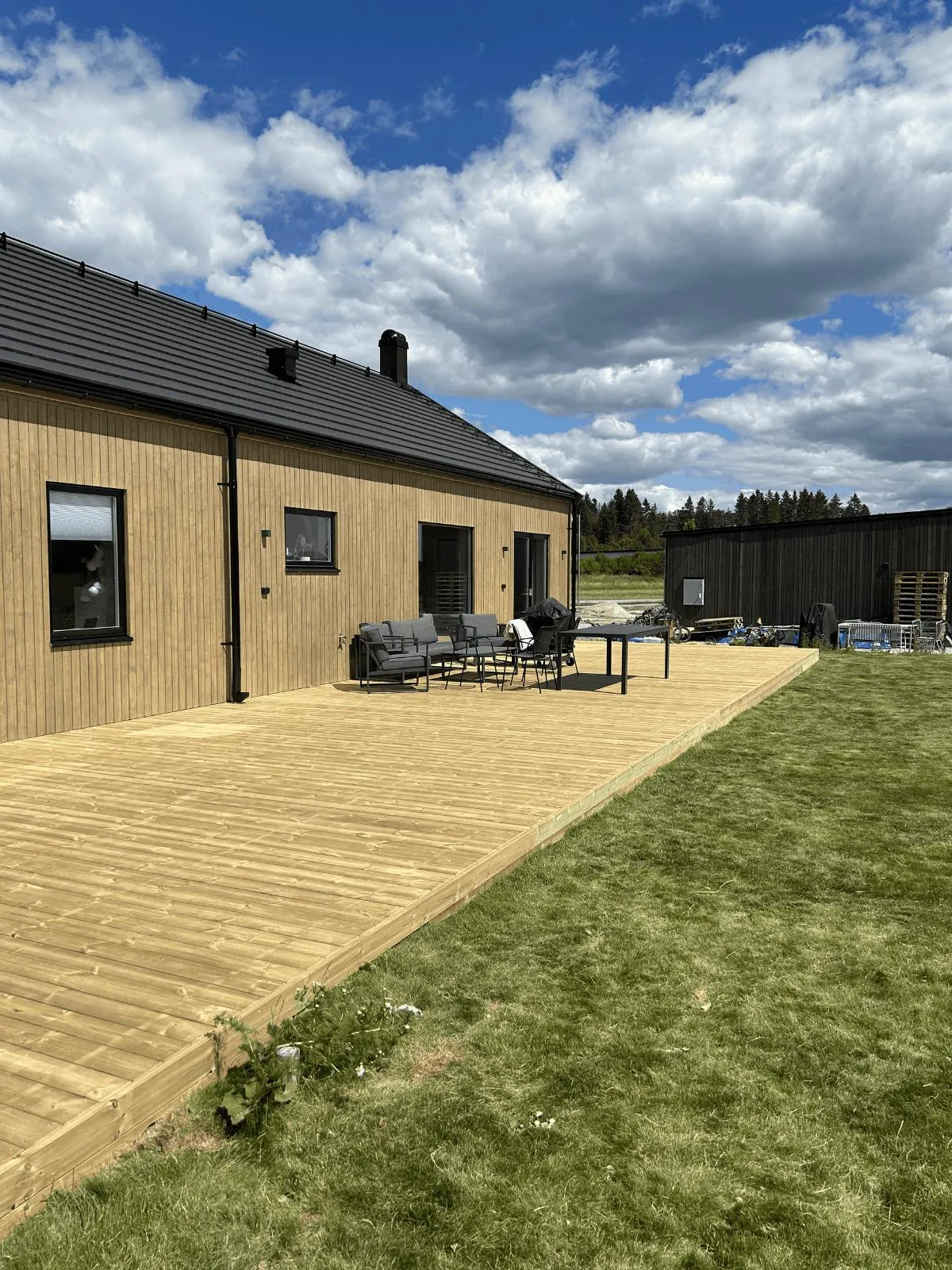 Modernt trähus med stor altan byggt av EM Byggtjänst